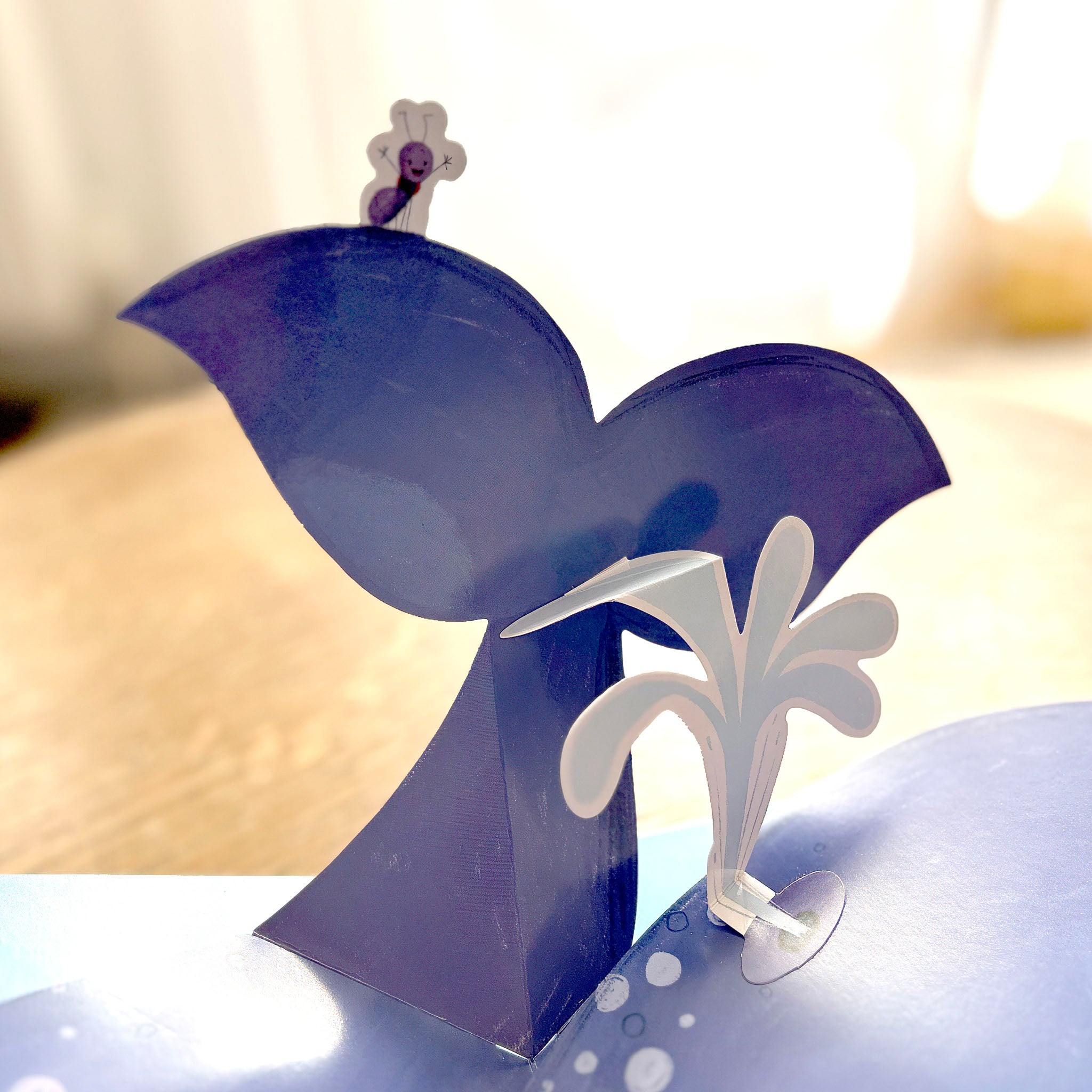 Pop-up children's book tail of a whale with ant standing on top